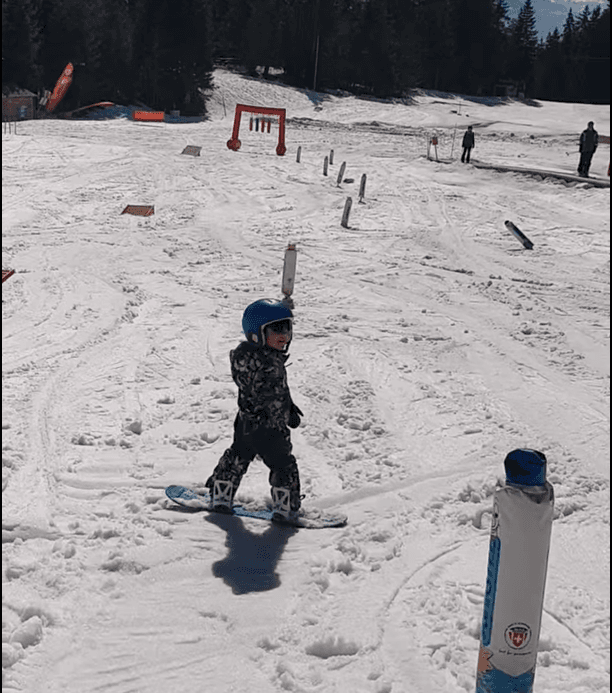 Young child snowboarding in Crans-Montana