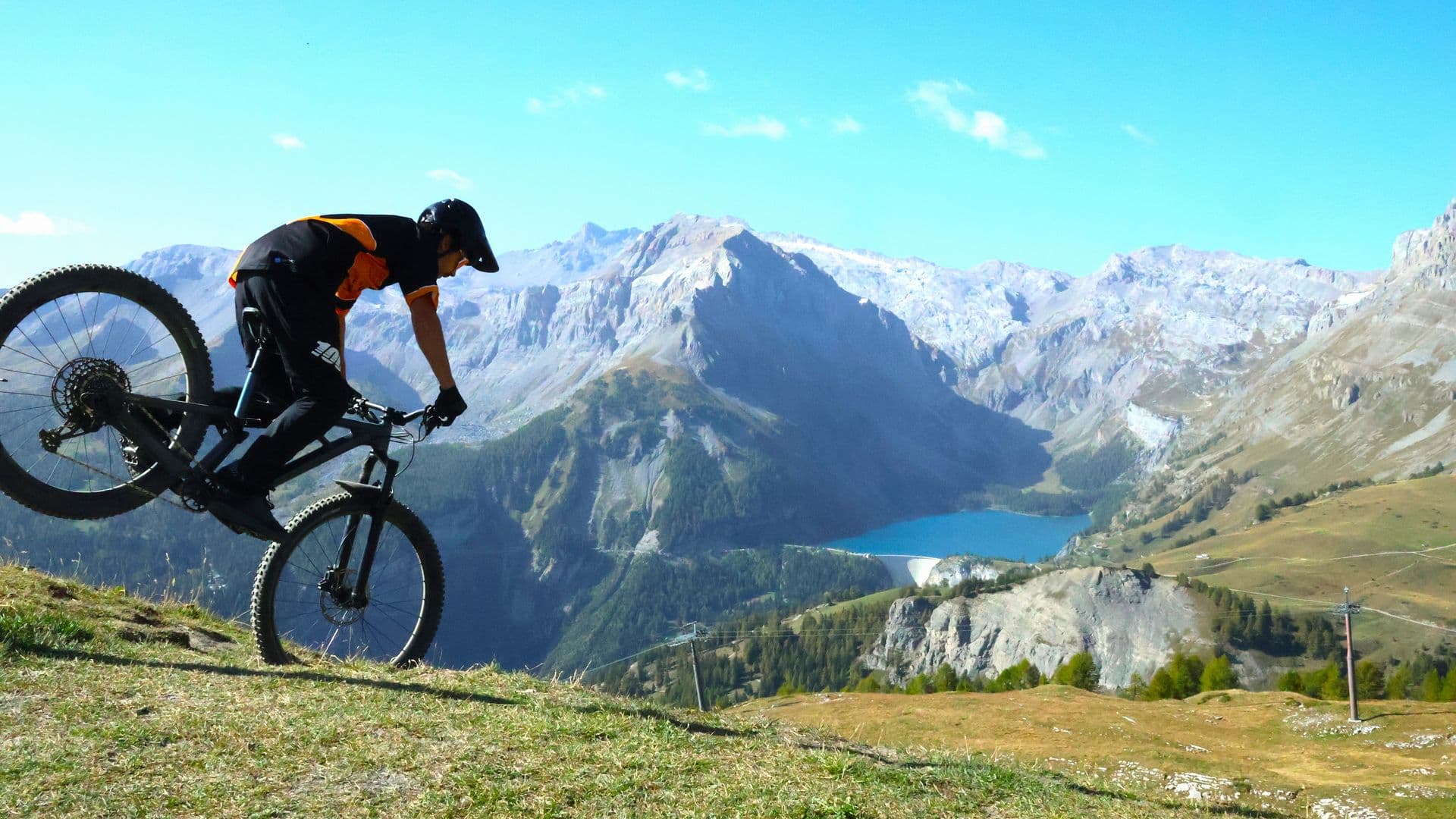 Mountainbike instructor form Enjoy the ride bike school doing a nose wheelie in Crans-Montana